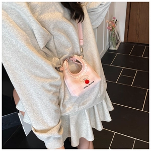 Detail of pink plaid mini bucket bag featuring cute puppy embroidery and lace trim