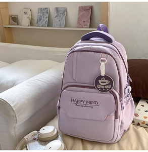 Detail of purple nylon backpack with Happy Mind lettering and multiple zipper pockets