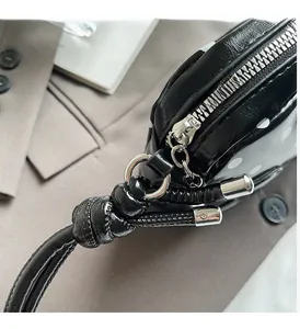 Detailed macro view of black polka dot handbag showing silver zipper and knotted handle detail