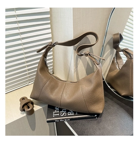 Detailed view of a brown pebbled leather hobo bag with dual straps and silver hardware