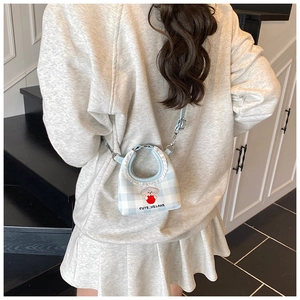 Detail of cute puppy bucket bag with blue plaid patterns and frill trim decoration