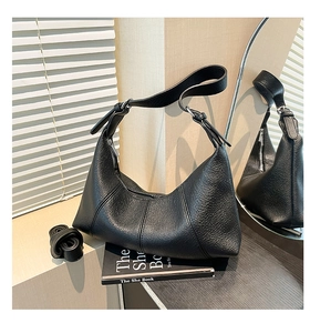 Close-up of black lychee texture handbag with silver hardware and adjustable strap