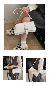 Detail showing the white minimalist baguette bag with silver buckle and dual straps