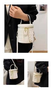 Detail view of the cylinder bucket bag featuring a quilted pattern and gold-tone zippers