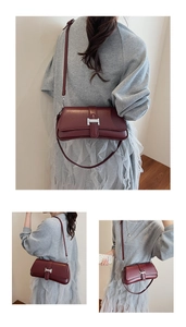 Detail view of the silver H-shaped buckle and fine leather texture of the burgundy baguette bag