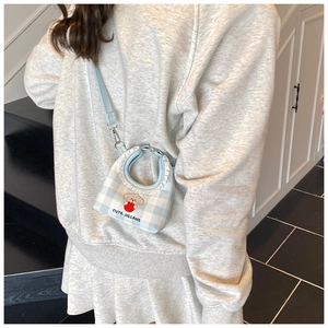 Detail view of light blue checkered mini bucket bag with lace trim and puppy patch