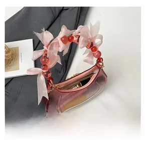 Detail view of pink jelly moon bag with decorative beads and silk bow showing internal capacity
