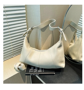 Detail of off-white lychee texture leather hobo bag with adjustable strap and stitching
