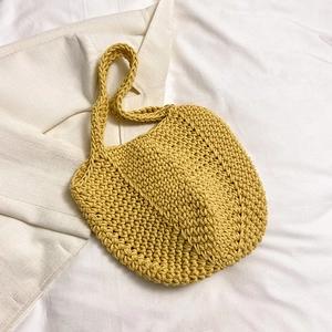 Detailed close-up showing the yellow handmade crochet weave texture of the beach tote bag