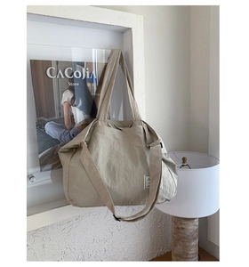 Detail view of canvas tote bag with adjustable shoulder strap and decorative fabric label