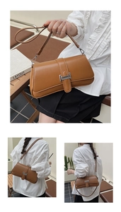 Detail view of a vintage brown baguette bag with silver buckle and adjustable strap