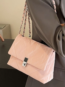 Borsa a tracolla trapuntata rosa con catena e finitura lucida indossata da modella