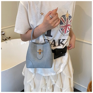 Detail of light blue leather bucket bag with gold metal twist lock and sturdy handle