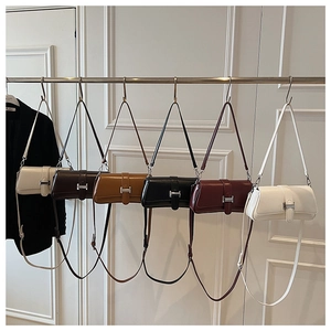 Row of minimalist leather crossbody bags in six colors with silver buckles and straps