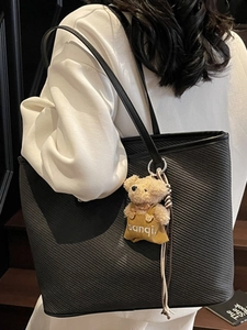 Sac fourre-tout noir texturé pour femme avec un joli pendentif ours sur une bandoulière