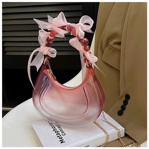 Close-up of pink gradient acrylic crescent bag with bow bead handle and gold chain