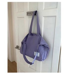 Detail of purple waterproof nylon tote bag with adjustable shoulder straps and pockets