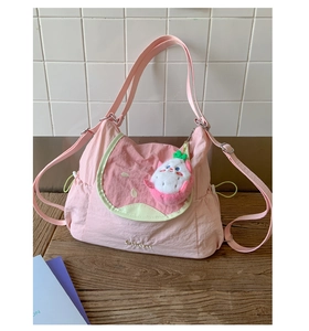Detailed close-up of fruit-themed tote bag with pink watermelon design and plush charm