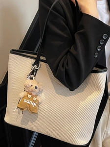 Grand sac cabas tissé beige pour femme avec bordure noire et accessoire charm d'ours