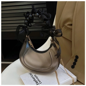 Detail of grey crescent bag with pearl beaded handle and black satin bows