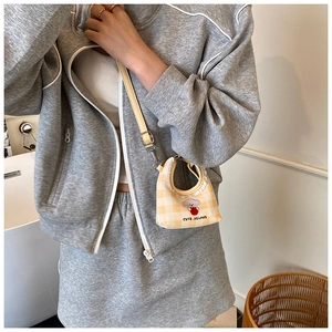 Detail of yellow checkerboard crossbody bag with cute animal embroidery and adjustable strap