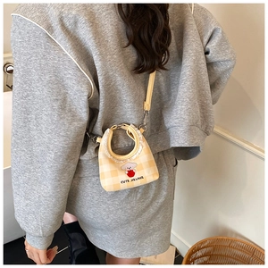 Detail showing mini yellow checkered bucket bag with lace trim and cute dog print