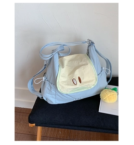 Detail of light blue nylon tote bag with cartoon embroidery and adjustable drawstring