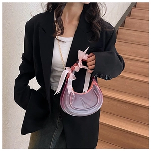 Close-up of pink and purple gradient crescent bag with ribbon bows and gold chain