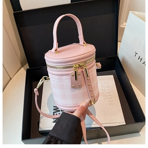 Pink quilted cylinder bag with gold hardware in a luxury gift box setting
