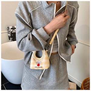Detail of yellow checkered mini bucket bag with cute puppy embroidery and thin strap