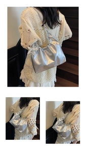 Detail of silver metallic tote bag with pleated hobo design and star charm accessory