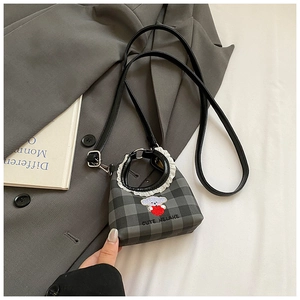 Close-up of mini plaid bucket bag with cute bear embroidery and white ruffle trim