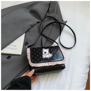 Detailaufnahme der schwarzen Umhängetasche mit rosa Rüschen und weißem Welpen-Patch