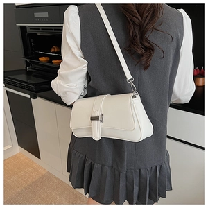 Detail view of the silver metal clasp and matte white texture of the baguette bag