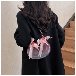 Detail of creative crescent bag in gradient pink resin with bow decoration and gold chain