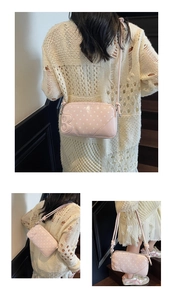 Detail view of pink polka dot underarm bag with 3D letter B and adjustable shoulder strap