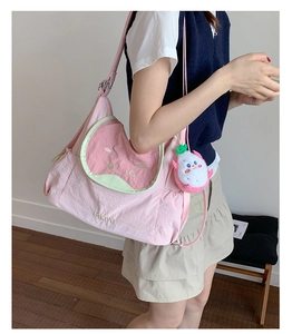 Pink watermelon shoulder bag with Guava embroidery and dragon fruit plush charm shown in use