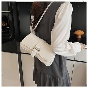 Detail of white rectangular shoulder bag with silver metal buckle and slim strap