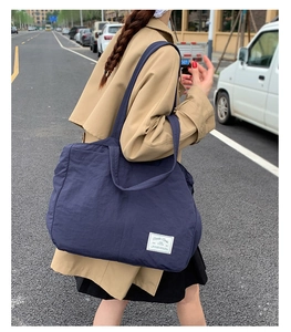 Navy blue large canvas tote bag shown on model for daily commuting style