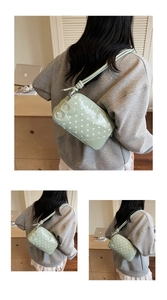 Detail of light green polka dot shoulder bag with cute cartoon patch and leather strap