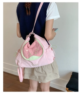 Detail of cute pink guava fruit shoulder bag with embroidered text on canvas material