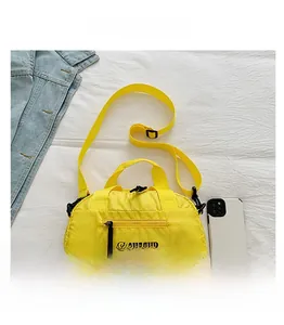 Détail du sac bandoulière en nylon jaune avec texture à carreaux et sangle réglable