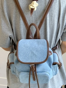 Minimalist canvas backpack in washed blue denim with brown leather straps for women