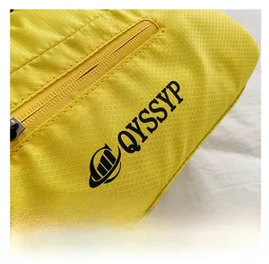 Détail du tissu en nylon ripstop jaune avec motif en losange et logo de marque sur le sac