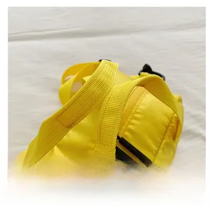 Détail d'un sac bandoulière en nylon jaune avec poignée tissée renforcée et texture quadrillée