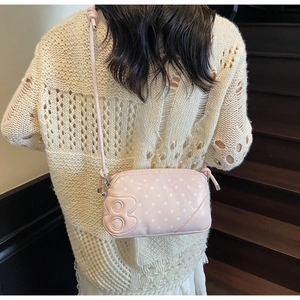 Detail of pink polka dot crossbody bag with 3D letter B and double zipper design