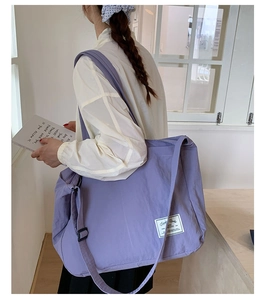 Detail of purple canvas tote bag with adjustable strap and minimalist white woven label
