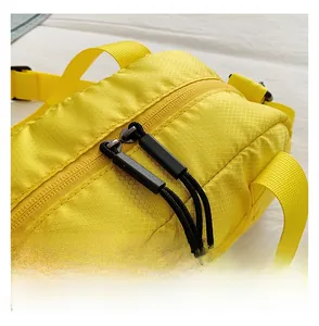 Détail de la double fermeture éclair fluide avec cordons noirs sur tissu ripstop jaune