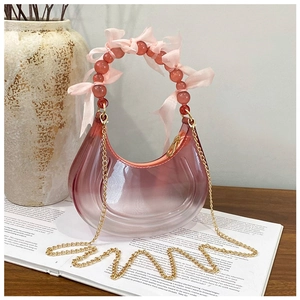 Detailed macro view of translucent purple crescent bag with beaded handle and pink bow