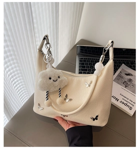 Détails du sac hobo blanc crème avec texture plissée et breloques papillon argentées